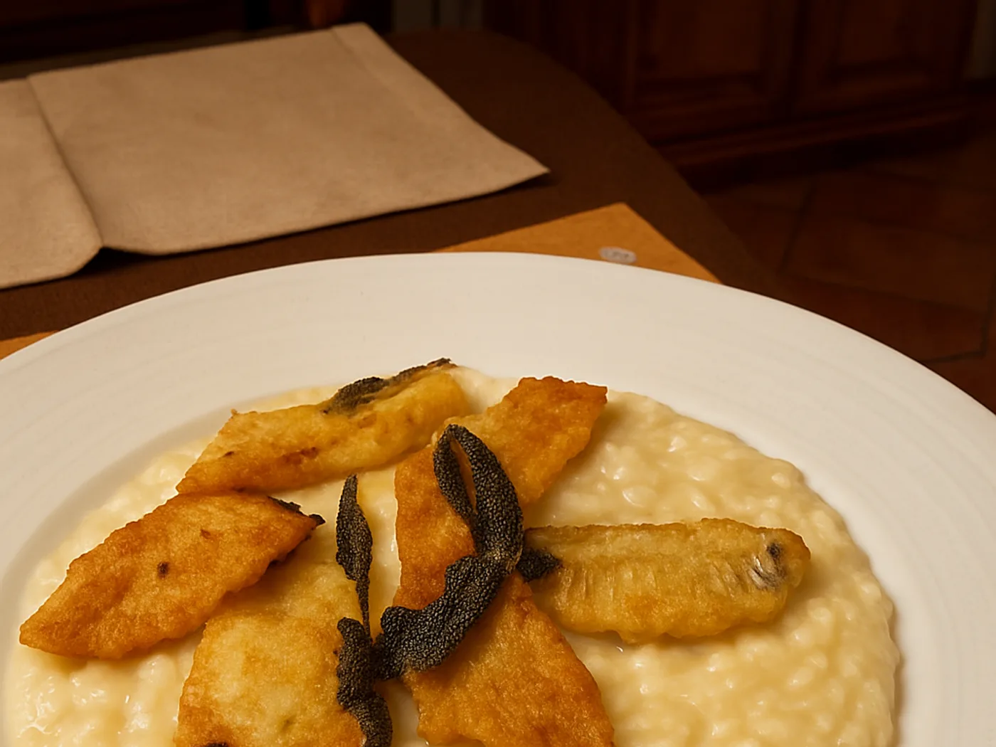 Risotto mantecato con filetti di pesce fritti e salvia