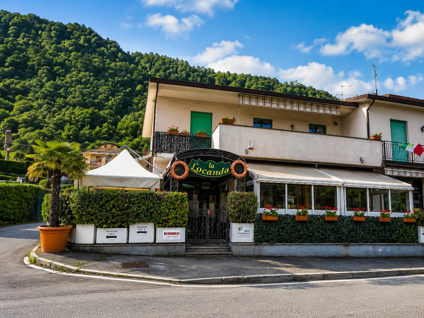 Esterno della Locanda di giorno, con veranda e collina alle spalle